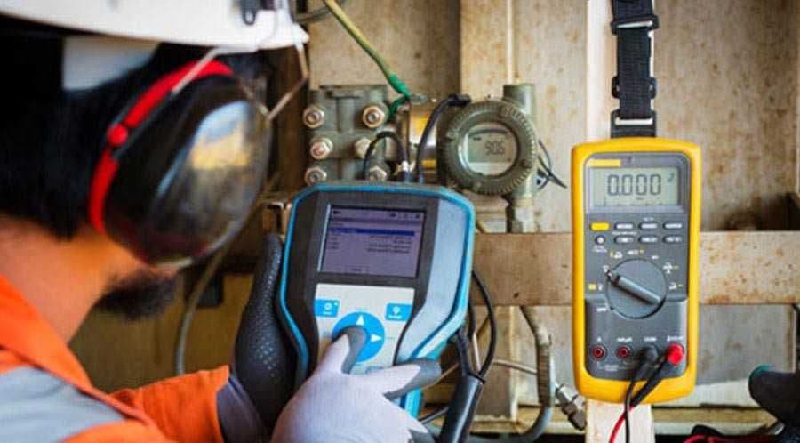 Technician testing a process transmitter with handheld instruments