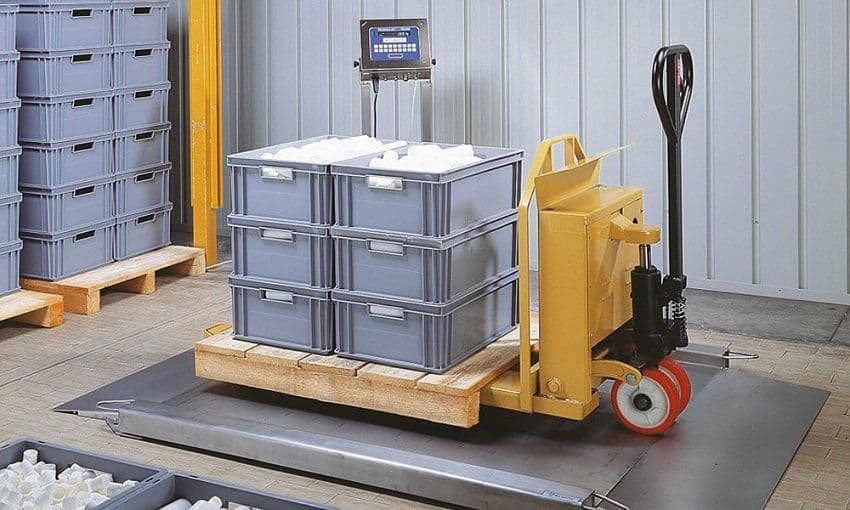 Pallet jack and stacked crates on a floor scale