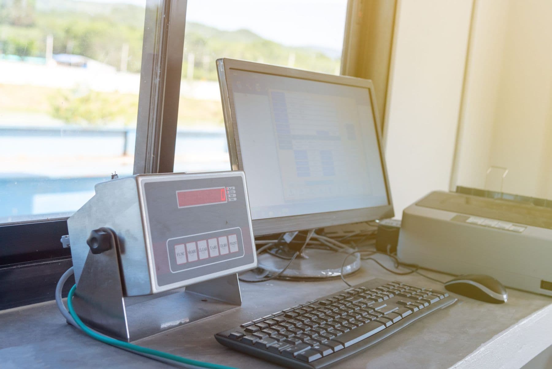 Weighbridge weight indicator beside a computer workstation