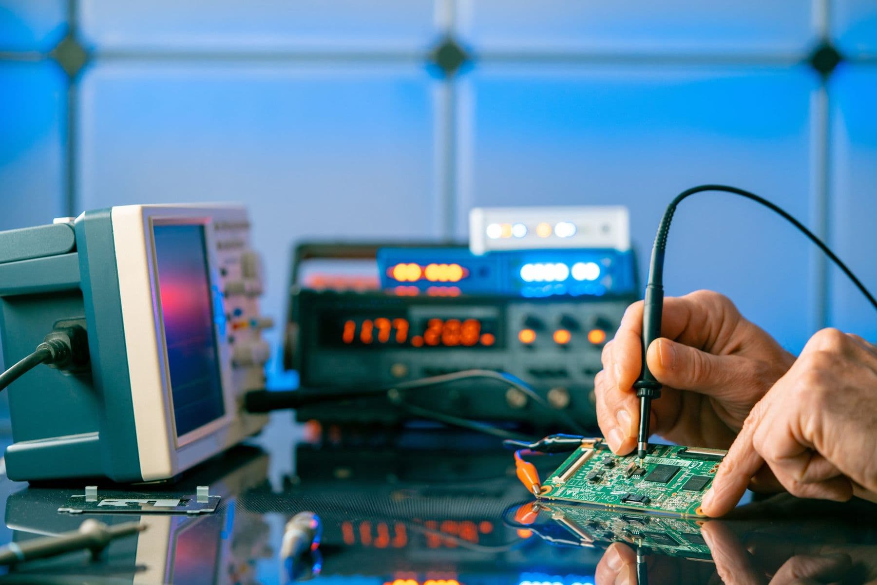 Technician testing a circuit board with electronic instruments