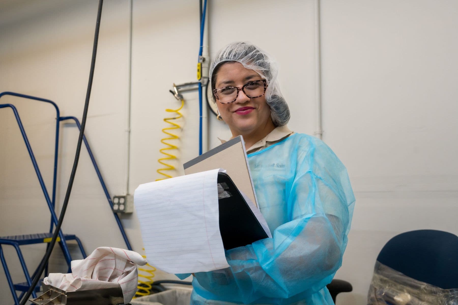MS Weights & Scales team member holding service records in a clean-room facility